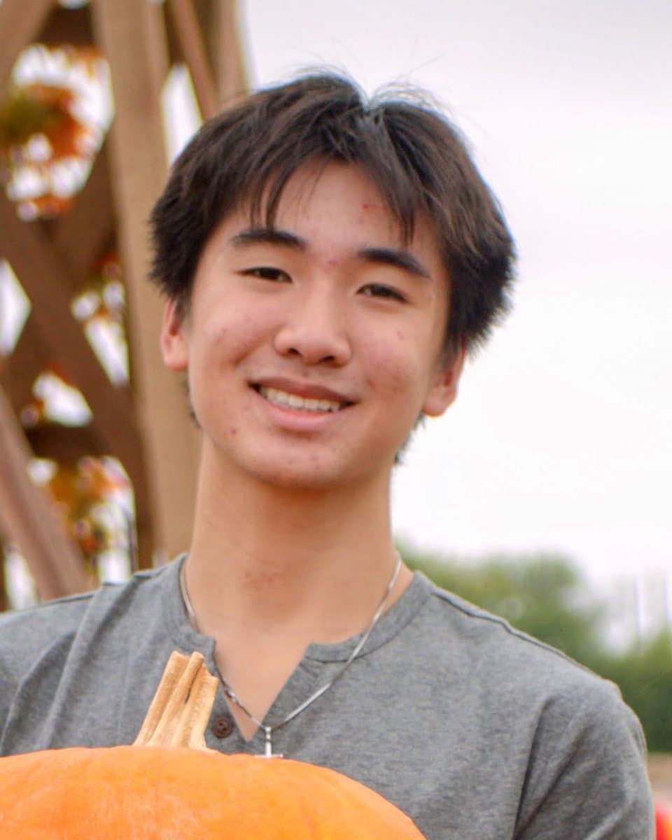Ashton Tran smiling outdoors at a pumpkin patch